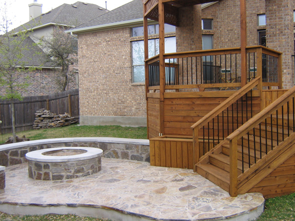 Flagstone patio with fire pit, bench retaining wall and adjoining deck
