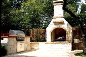 Natural stone patio and outdoor fireplace by Archadeck of Austin